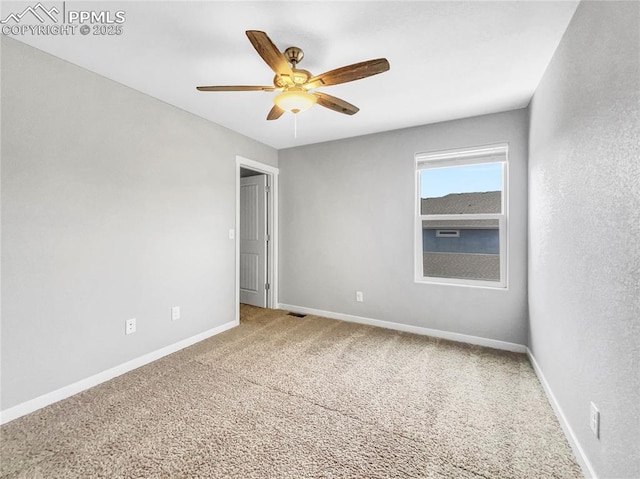 unfurnished room with carpet, visible vents, baseboards, and ceiling fan