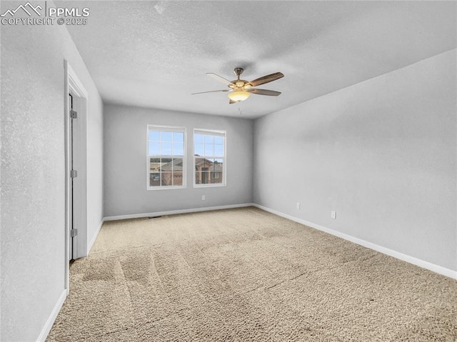 carpeted spare room featuring a ceiling fan, baseboards, and a textured ceiling