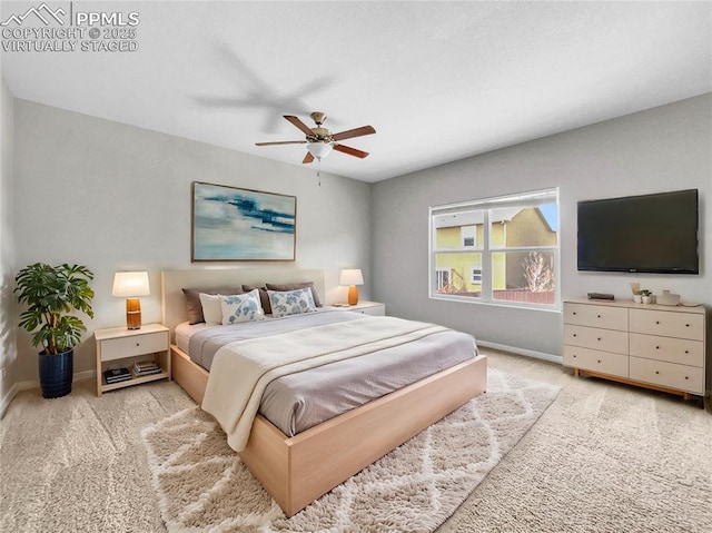 bedroom with light colored carpet, ceiling fan, and baseboards