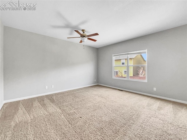 carpeted empty room featuring visible vents, a ceiling fan, and baseboards