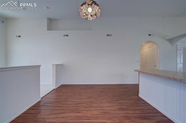 unfurnished room with visible vents, baseboards, and wood finished floors