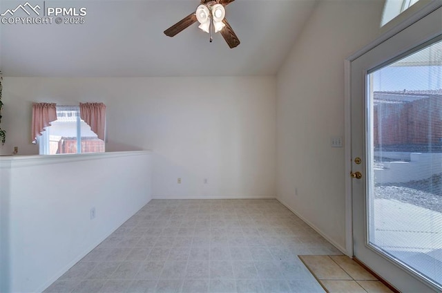 empty room with lofted ceiling, ceiling fan, and baseboards