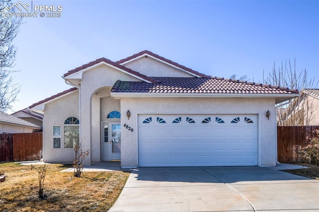 single story home featuring a tiled roof, fence, concrete driveway, and stucco siding