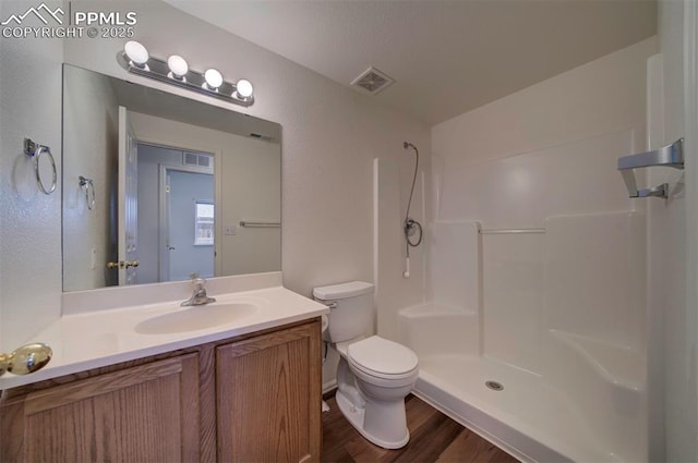 full bathroom with visible vents, vanity, toilet, and walk in shower