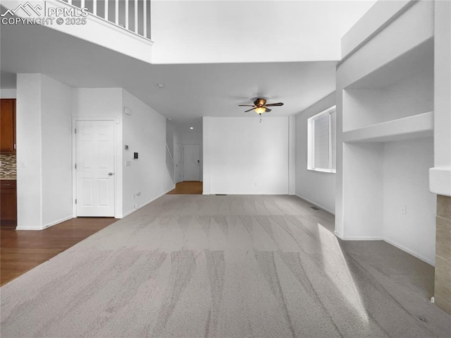 unfurnished living room featuring ceiling fan and carpet floors