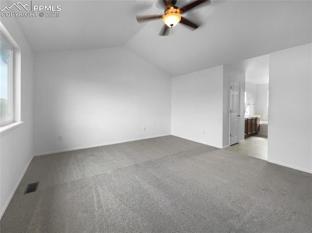 interior space with ceiling fan, carpet flooring, and vaulted ceiling