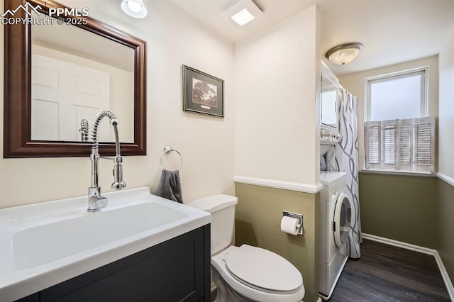 full bathroom with toilet, vanity, wood finished floors, washer / dryer, and baseboards