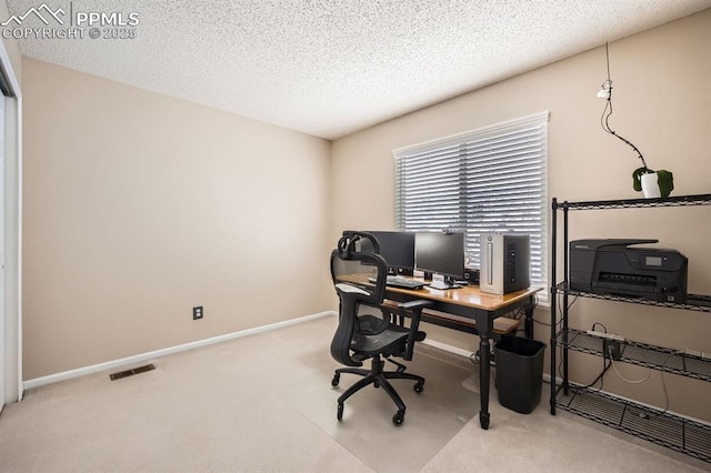 carpeted office space with baseboards, visible vents, and a textured ceiling