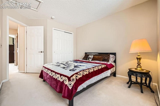 bedroom featuring a textured ceiling, carpet floors, a closet, and baseboards