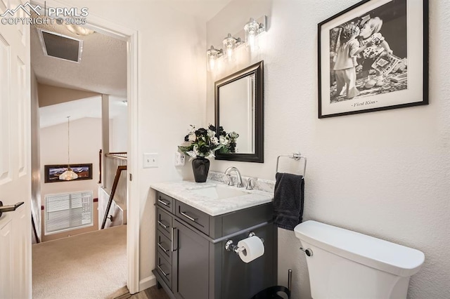 half bathroom featuring toilet, vaulted ceiling, vanity, and visible vents