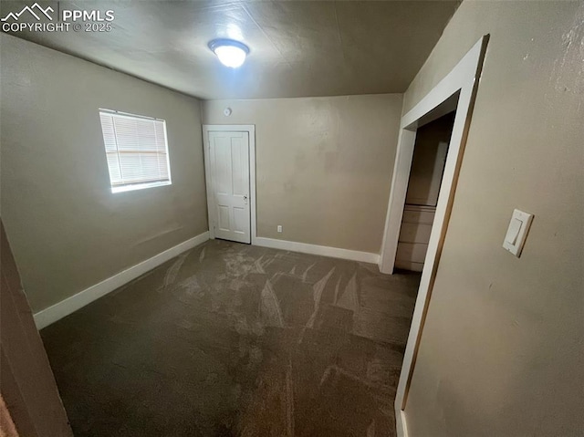 unfurnished room with carpet floors and baseboards