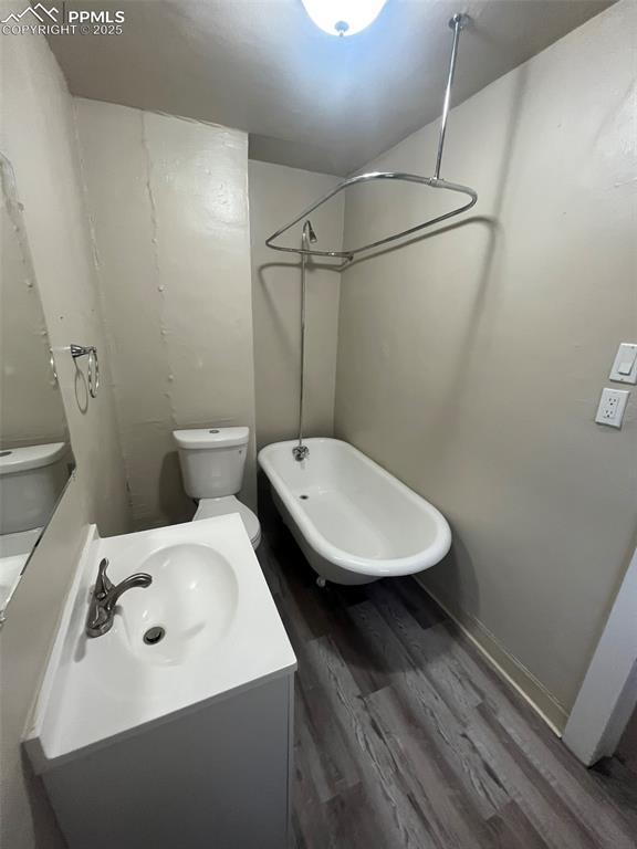 full bath featuring a bathtub, toilet, vanity, wood finished floors, and walk in shower