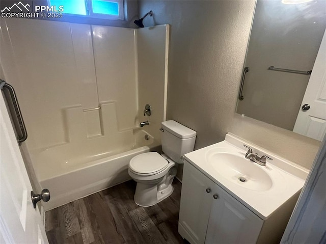 full bathroom with a textured wall, toilet, wood finished floors, bathtub / shower combination, and vanity