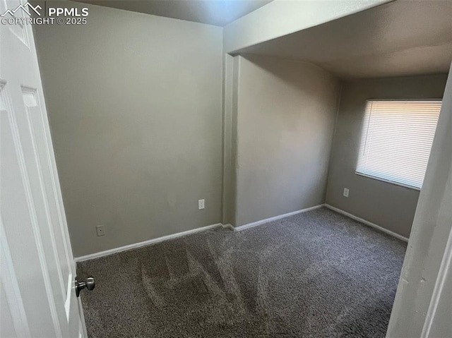 carpeted spare room featuring baseboards