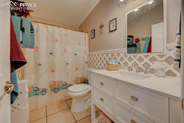 bathroom with tile patterned floors, vanity, tile walls, and toilet