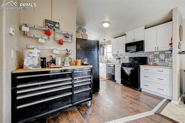 kitchen featuring dark hardwood / wood-style flooring, black appliances, white cabinets, hanging light fixtures, and decorative backsplash