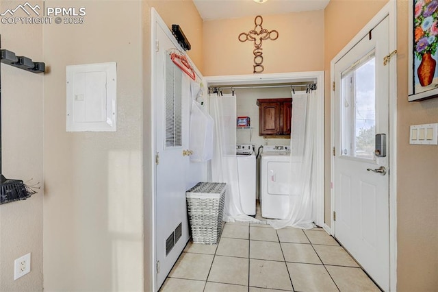 interior space featuring electric panel, light tile patterned flooring, and independent washer and dryer