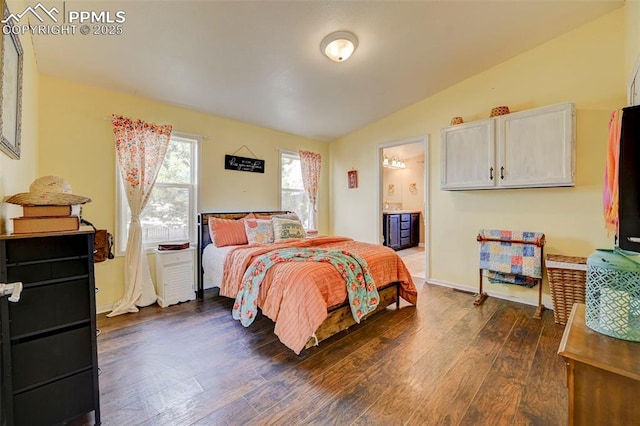 bedroom with ensuite bathroom, vaulted ceiling, and dark hardwood / wood-style flooring