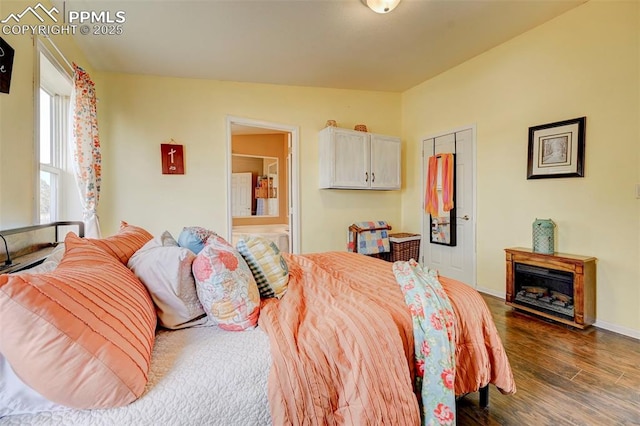 bedroom featuring dark hardwood / wood-style flooring and ensuite bath