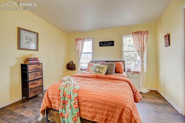 bedroom with dark wood-type flooring, vaulted ceiling, and multiple windows