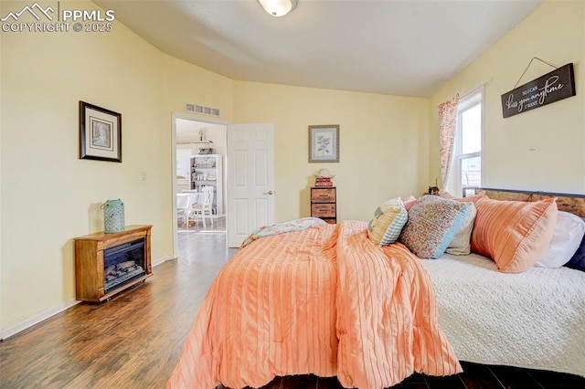 bedroom featuring vaulted ceiling and dark hardwood / wood-style flooring