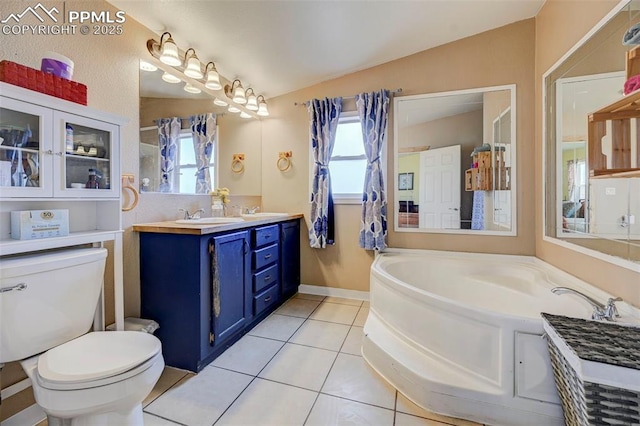 bathroom featuring tile patterned floors, toilet, vaulted ceiling, a bathing tub, and vanity