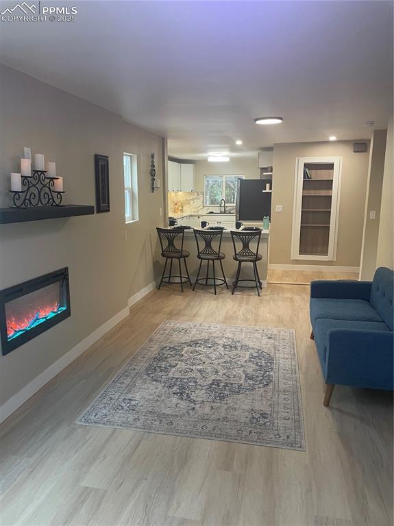 living room featuring sink, a wealth of natural light, and light hardwood / wood-style flooring