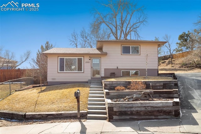 split level home featuring stairs and fence