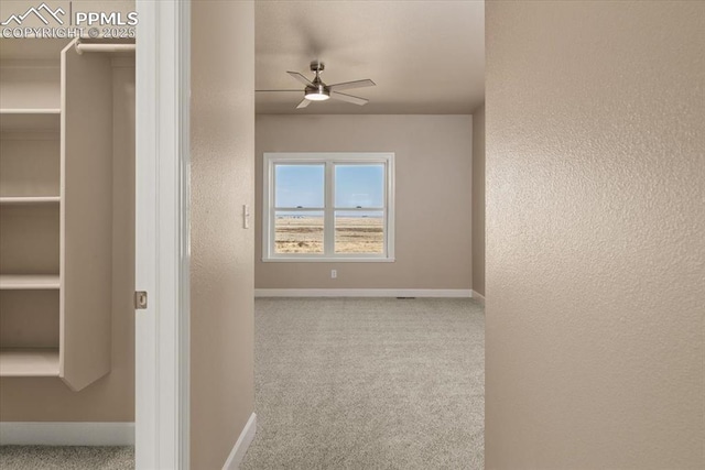 interior space featuring ceiling fan and light colored carpet