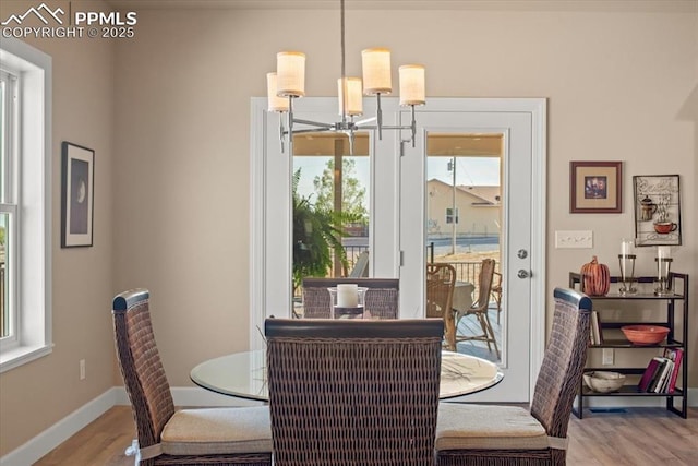 dining area with hardwood / wood-style floors and an inviting chandelier