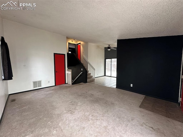 spare room with carpet, ceiling fan, and a textured ceiling