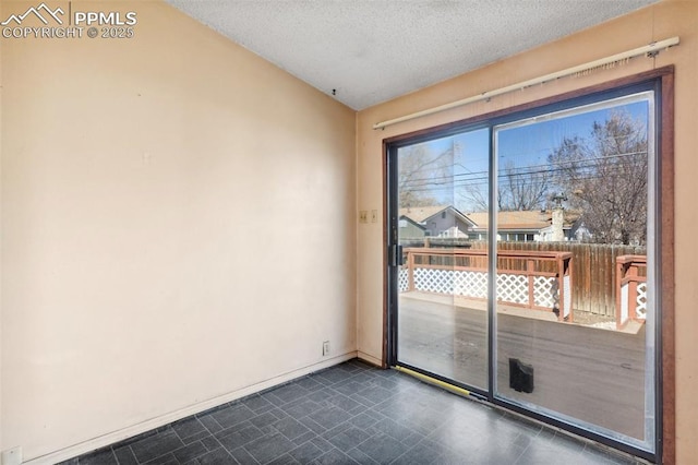 unfurnished room featuring a textured ceiling and baseboards