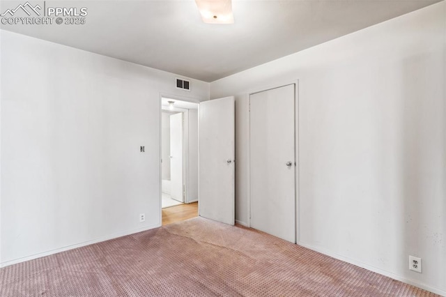 unfurnished bedroom featuring a closet, carpet flooring, and visible vents