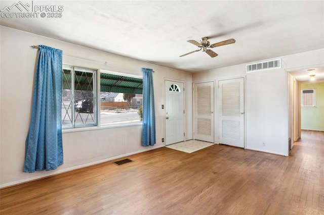 entrance foyer with baseboards, ceiling fan, visible vents, and wood finished floors