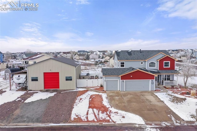 view of front facade featuring a garage, a residential view, and fence