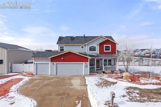 traditional home with a garage, covered porch, fence, and concrete driveway