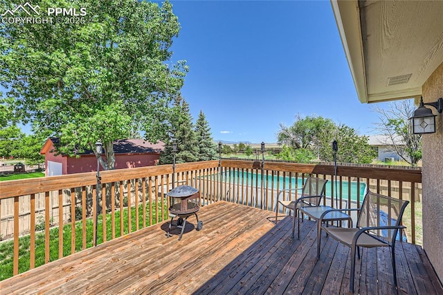 wooden terrace featuring a fenced in pool