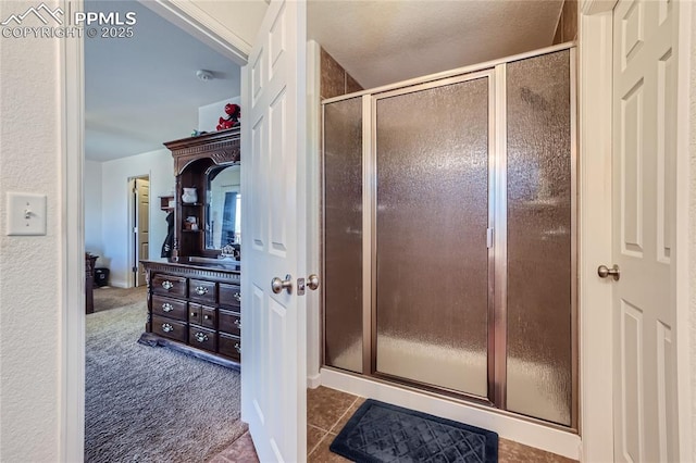 bathroom with tile patterned flooring and a shower stall