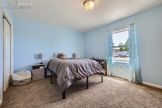 carpeted bedroom featuring visible vents, baseboards, and a closet