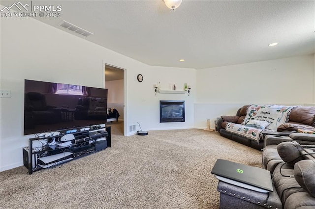 carpeted living area with recessed lighting, a glass covered fireplace, visible vents, and baseboards