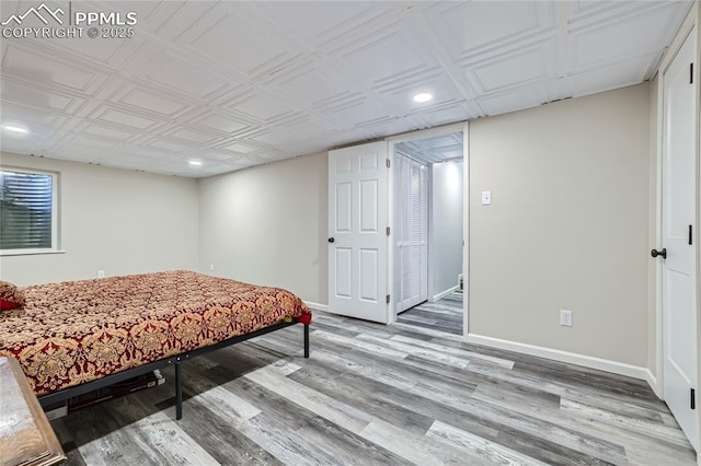 bedroom with recessed lighting, wood finished floors, and baseboards