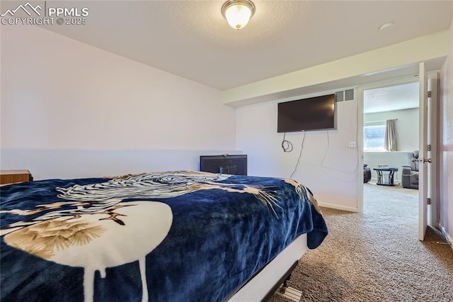 bedroom featuring carpet floors, visible vents, baseboards, and a textured ceiling