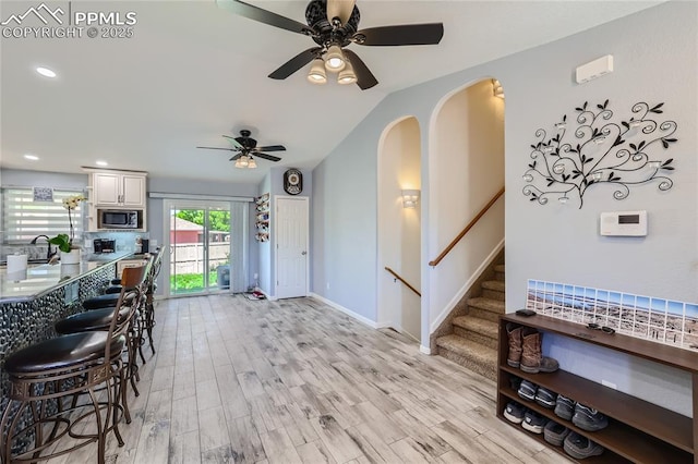 interior space with light wood-style flooring, recessed lighting, white cabinetry, baseboards, and stainless steel microwave