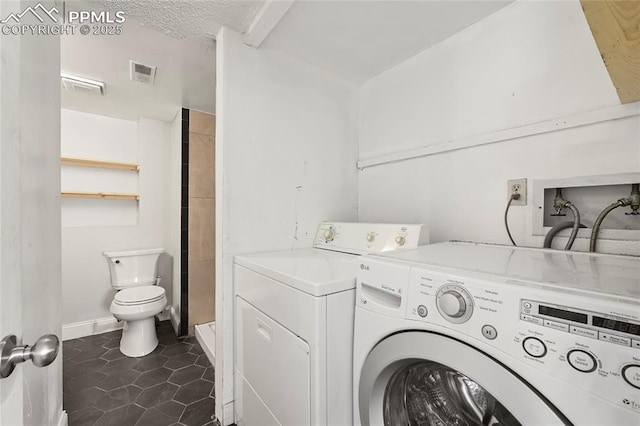 laundry room featuring laundry area, dark tile patterned flooring, independent washer and dryer, and visible vents