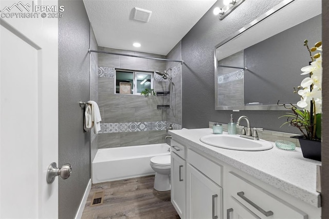 bathroom featuring visible vents, vanity, toilet, and a textured ceiling