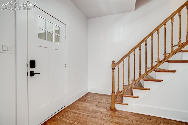 foyer featuring light wood-style floors, stairway, and baseboards