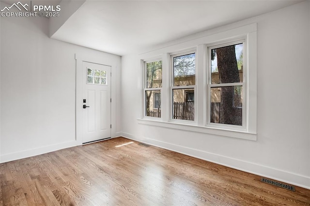 entryway with light wood-style flooring, visible vents, and baseboards