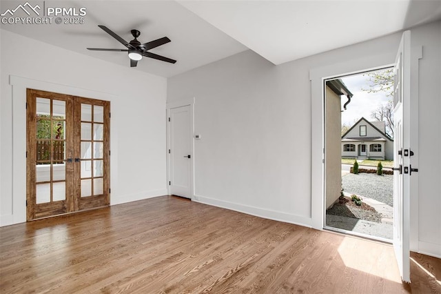 unfurnished room with plenty of natural light, baseboards, wood finished floors, and french doors