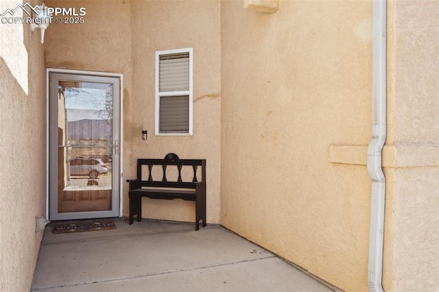 property entrance with stucco siding