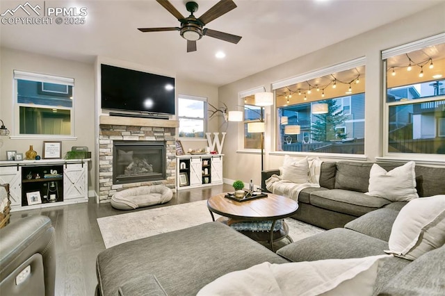 living room with ceiling fan, a fireplace, baseboards, and wood finished floors